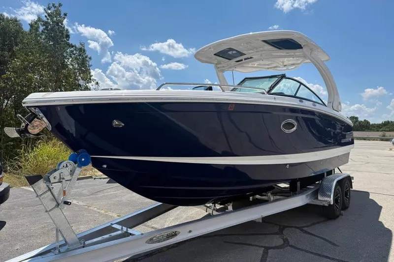 Slide: The Image of 2022 Chaparral 28 Surf boat on trailer under blue sky. - 1
