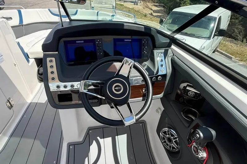Slide: The Image of 2022 Chaparral 28 Surf boat dashboard with steering wheel and dual Simrad displays. - 13