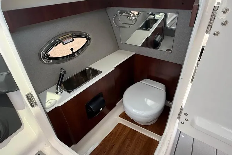 Slide: The Image of 2022 Chaparral 28 Surf boat interior bathroom with sink, toilet, and mirror. - 18