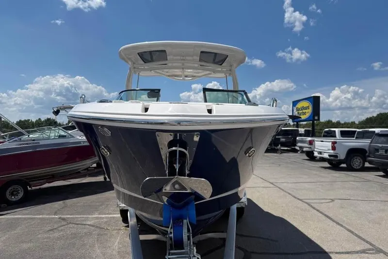 Slide: The Image of 2022 Chaparral 28 Surf boat displayed outdoors on a sunny day. - 2