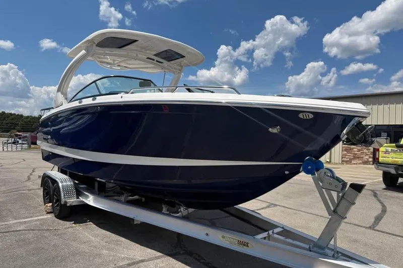 Slide: The Image of 2022 Chaparral 28 Surf boat on trailer under a blue sky. - 3