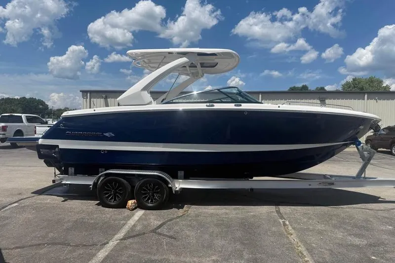 Slide: The Image of 2022 Chaparral 28 Surf boat on trailer under a blue sky. - 4