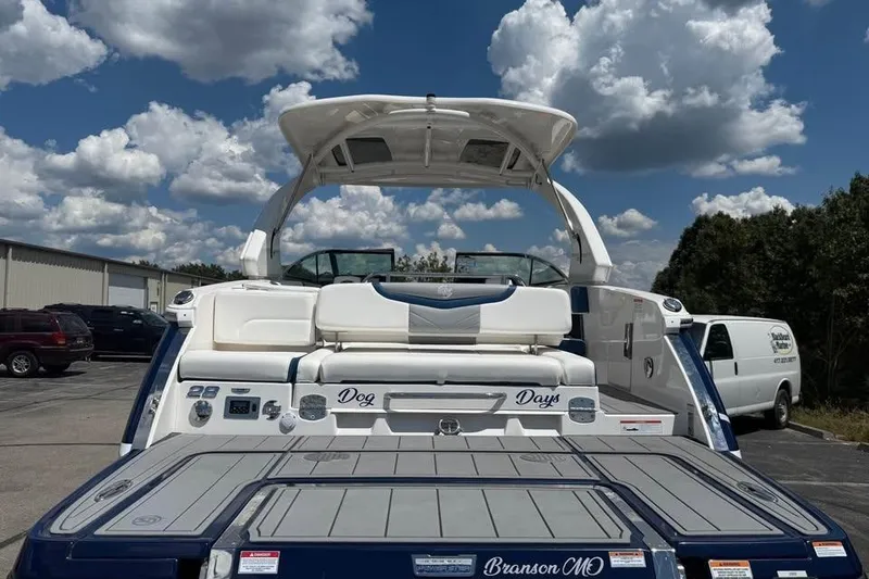 Slide: The Image of 2022 Chaparral 28 Surf boat with seating, parked outdoors under a cloudy sky. - 7