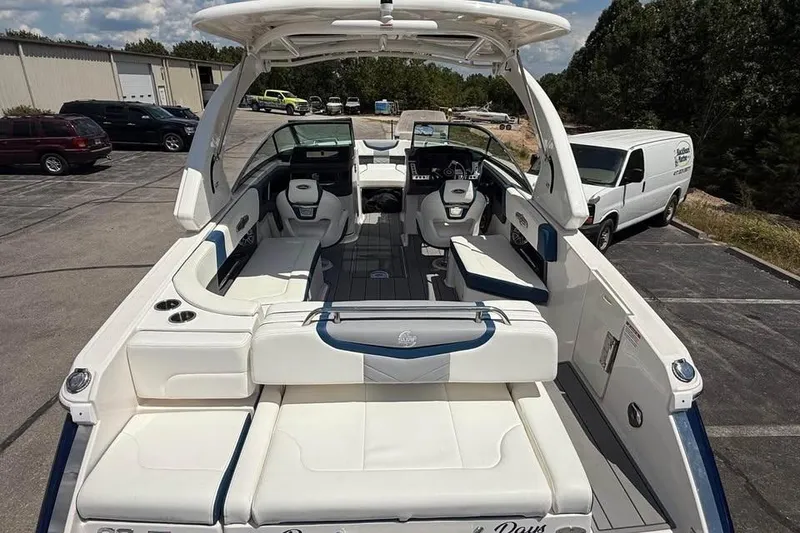 Slide: The Image of 2022 Chaparral 28 Surf boat with spacious seating and modern design in a parking lot. - 8