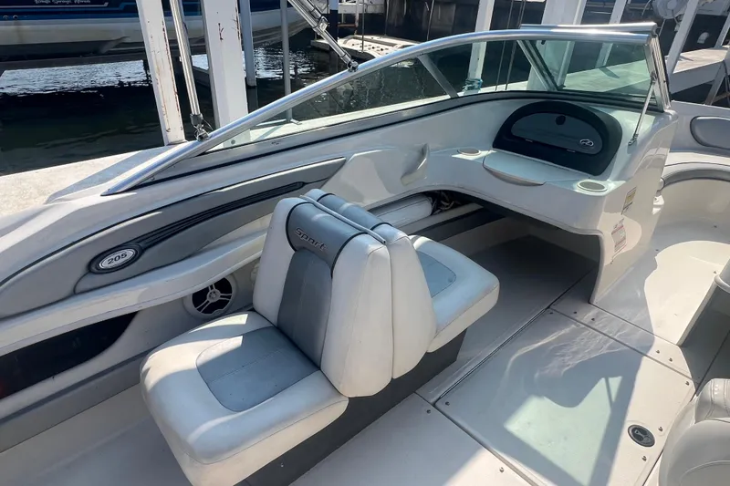 Slide: The Image of 2008 Sea Ray 205 Sport boat interior with seating and dashboard, docked at marina. - 4