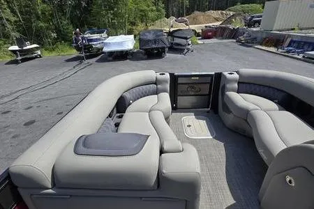 Slide: The Image of 2023 Barletta L25UCA pontoon boat with spacious seating, parked outdoors. - 11
