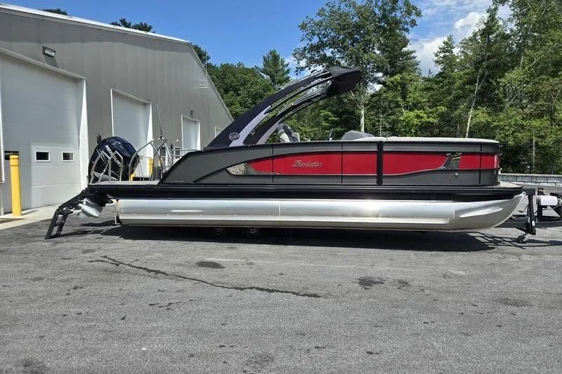 Slide: The Image of 2023 Barletta L25UCA pontoon boat parked outside a building, featuring a sleek design. - 16