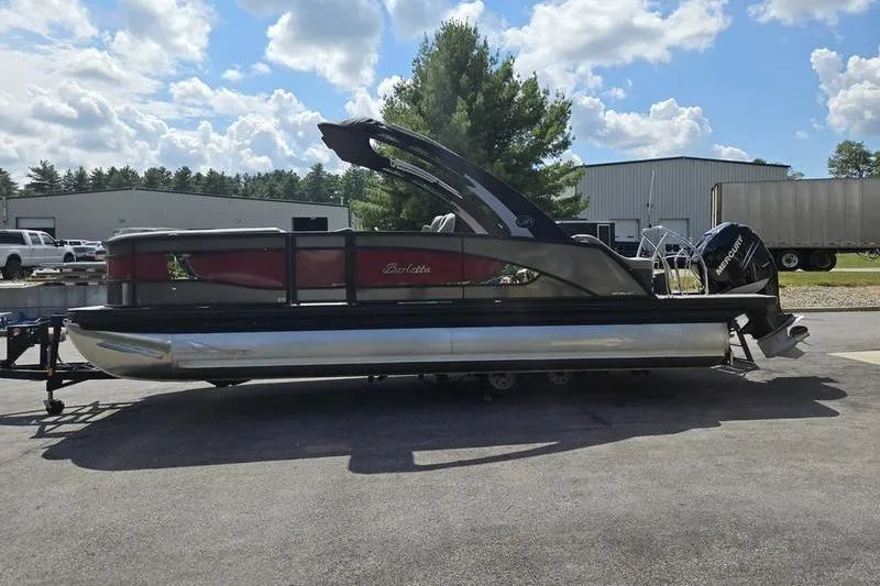Slide: The Image of 2023 Barletta L25UCA pontoon boat parked outdoors under a partly cloudy sky. - 17