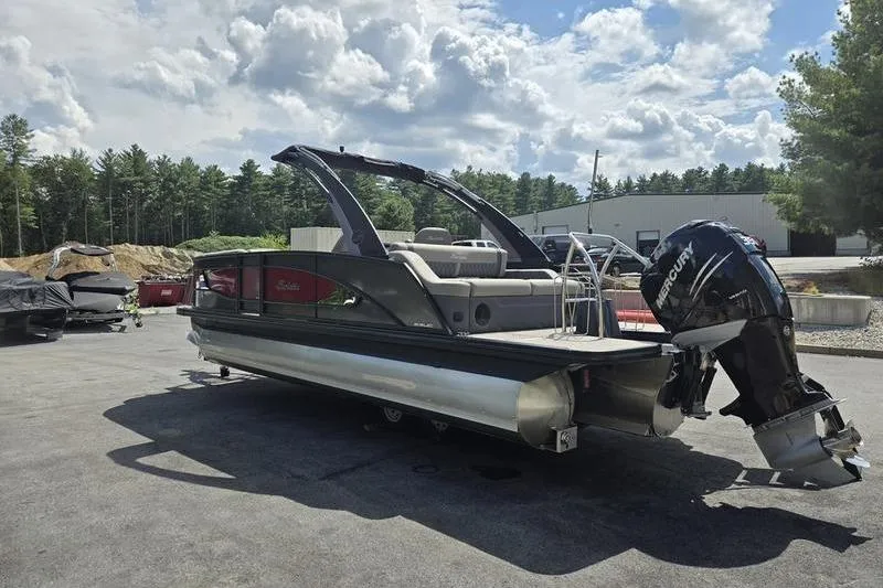 Slide: The Image of 2023 Barletta L25UCA pontoon boat with Mercury outboard motor, parked outdoors. - 21