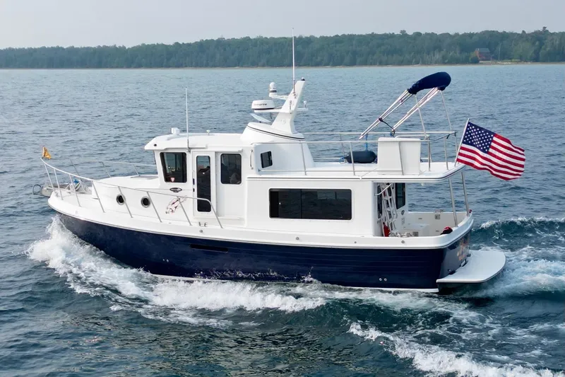 The Image of 2018 American Tug 365 cruising on open water with American flag. - 1