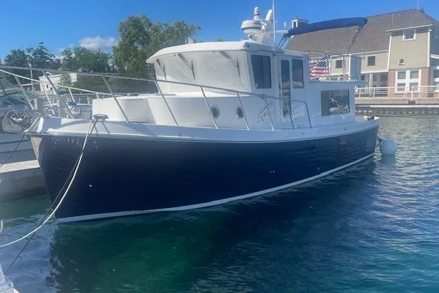 Slide: The Image of American Tug 365, 2018 model, docked in a marina with clear blue water. - 12