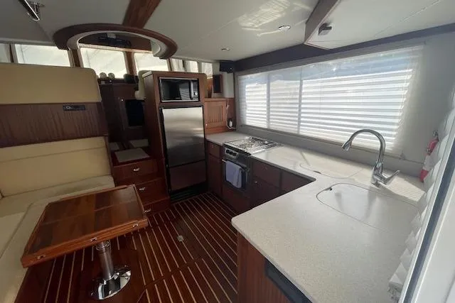 Slide: The Image of Interior of 2018 American Tug 365, featuring modern kitchen and dining area with wood accents. - 29