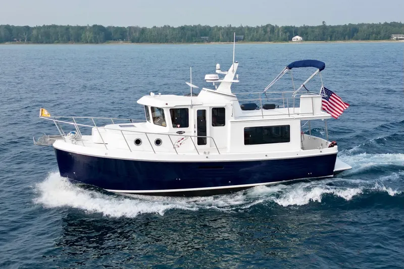 Slide: The Image of 2018 American Tug 365 cruising on open water with American flag. - 3