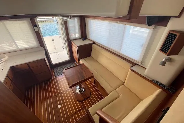 Slide: The Image of Interior of 2018 American Tug 365 with wood flooring and beige seating. - 30