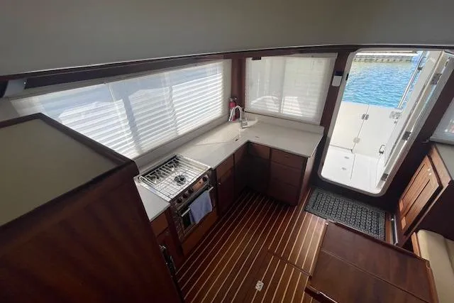 Slide: The Image of Interior of 2018 American Tug 365, featuring a compact kitchen with wood flooring. - 31