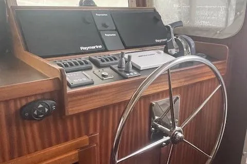 Slide: The Image of 2018 American Tug 365 helm with Raymarine navigation and wooden steering wheel. - 47