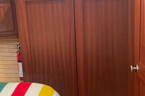 Slide: The Image of Interior of 2018 American Tug 365 with wooden cabinetry and colorful bedding. - 54