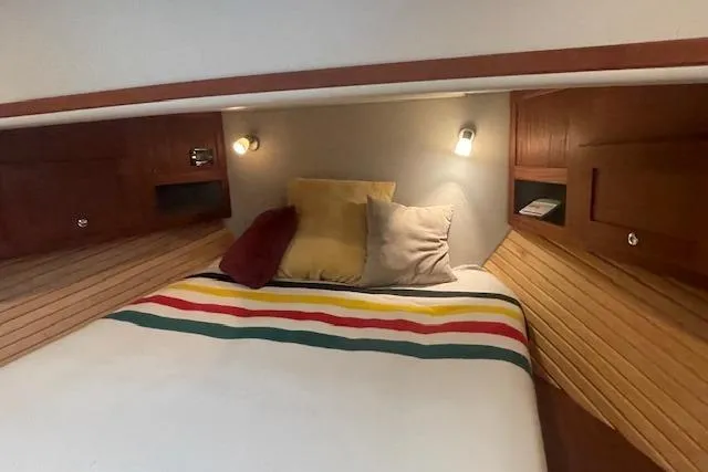 Slide: The Image of Cozy cabin interior of 2018 American Tug 365 with striped bedding and wooden accents. - 63