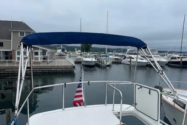 Slide: The Image of American Tug 365 (2018) docked at a marina with a blue canopy and American flag. - 66