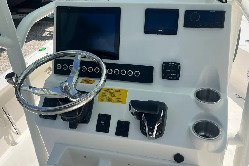 Slide: The Image of 2025 Key West 250 Bay Reef boat console with steering wheel and electronic controls. - 10