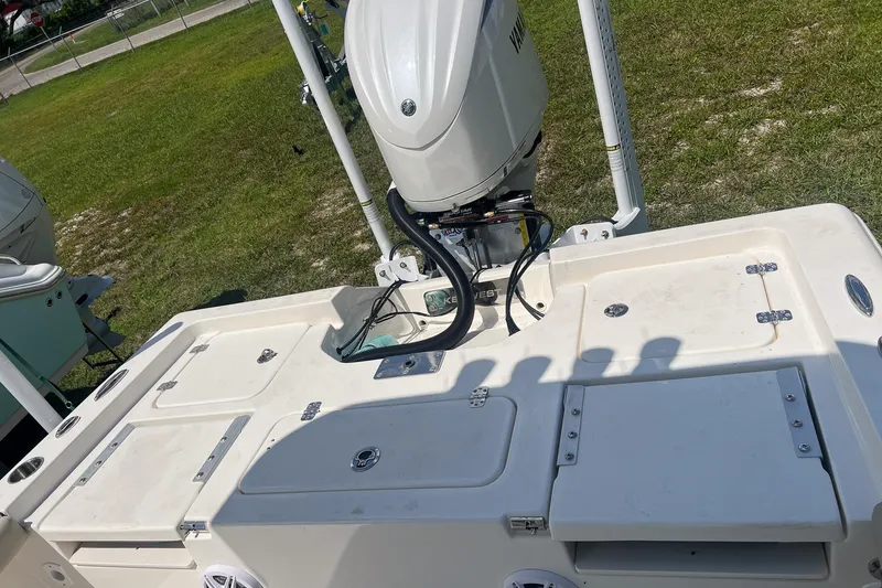 Slide: The Image of 2025 Key West 250 Bay Reef boat with Yamaha outboard engine, parked on grass. - 12