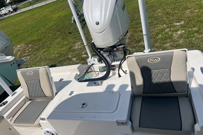 Slide: The Image of 2025 Key West 250 Bay Reef boat with cushioned seating and outboard motor. - 13