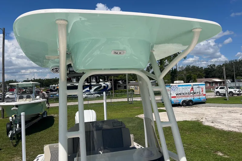 Slide: The Image of 2025 Key West 250 Bay Reef boat with T-top, displayed outdoors on a sunny day. - 17