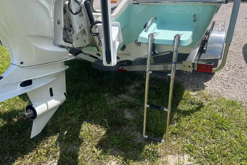 Slide: The Image of 2025 Key West 250 Bay Reef boat with ladder and outboard motor on grass. - 8