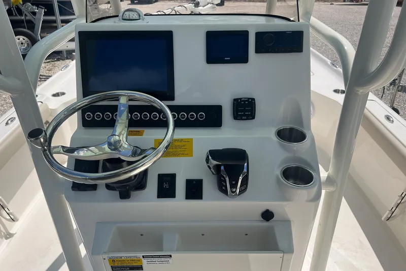 Slide: The Image of 2025 Key West 250 Bay Reef boat console with steering wheel, controls, and display screens. - 9