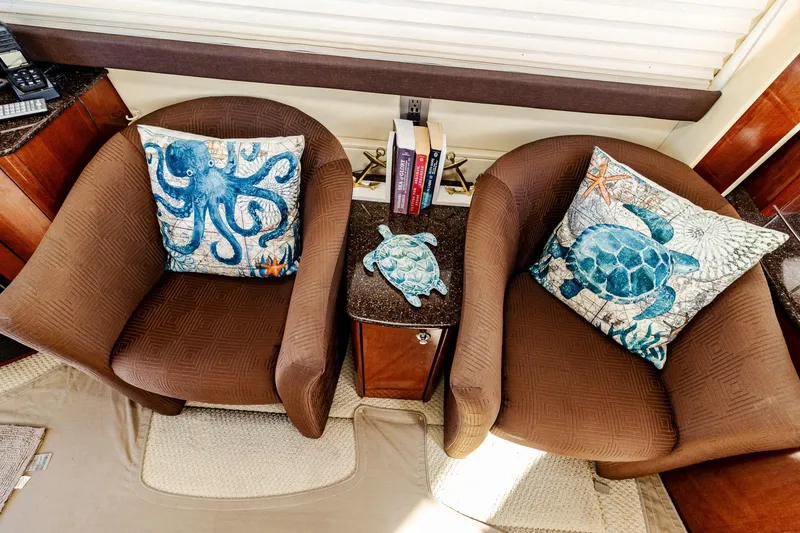 Slide: The Image of Two brown chairs with ocean-themed pillows and books on a 2009 Meridian 391 Sedan. - 28