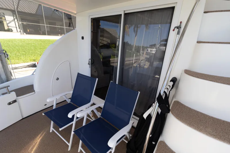 Slide: The Image of 2009 Meridian 391 Sedan yacht deck with blue chairs and spiral staircase. - 6