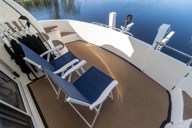 Slide: The Image of 2009 Meridian 391 Sedan yacht deck with blue chairs overlooking calm water. - 7