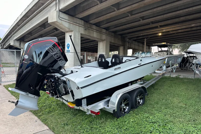 The Image of 2025 Nitra Boats 22 Supersport on trailer under bridge, showcasing sleek design and powerful engine. - 1