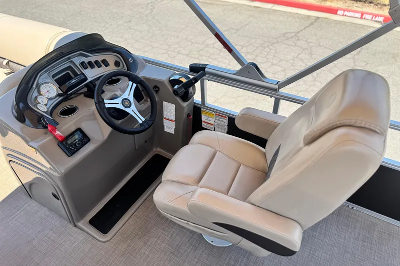 Slide: The Image of 2023 Sun Tracker SportFish 20 DLX boat cockpit with steering wheel and captain's chair. - 20