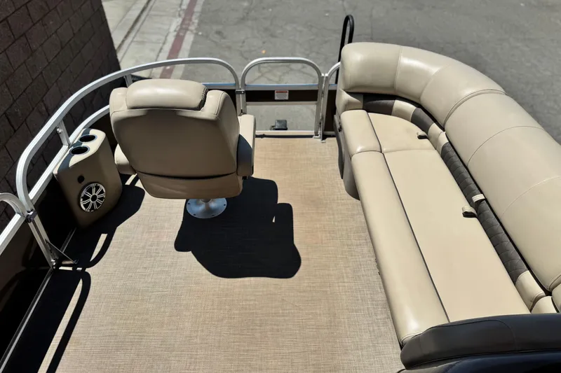 Slide: The Image of 2023 Sun Tracker SportFish 20 DLX pontoon boat interior with beige seating and speaker. - 9