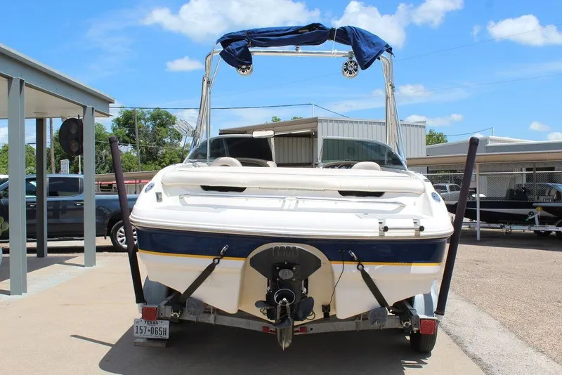 Slide: The Image of 2000 Chaparral 196 SSi boat on trailer, parked outdoors under a clear blue sky. - 7