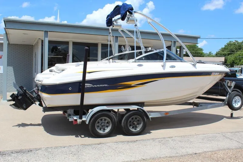 Slide: The Image of 2000 Chaparral 196 SSi boat on trailer, parked outside a building under a clear blue sky. - 9