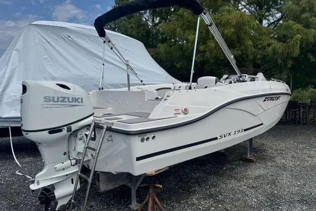 Slide: The Image of 2024 Starcraft SVX 191 OB boat with Suzuki outboard motor, parked on gravel. - 1