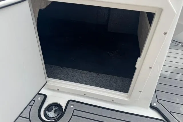 Slide: The Image of 2024 Starcraft SVX 191 OB boat storage compartment with gray flooring. - 11