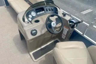 Slide: The Image of 2021 Sun Tracker Party Barge 18 DLX boat dashboard with steering wheel and controls. - 3