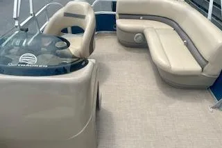 Slide: The Image of 2021 Sun Tracker Party Barge 18 DLX interior with beige seating and helm. - 8