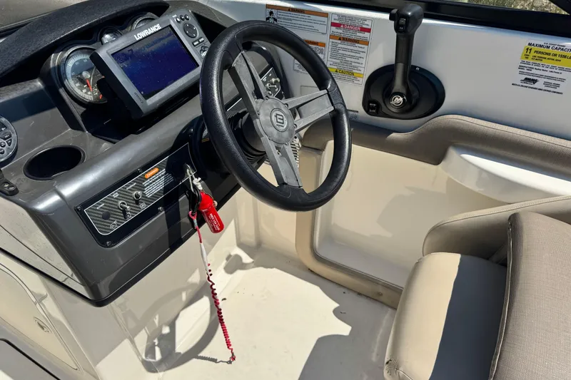 Slide: The Image of 2017 Bayliner 190 Deck Boat cockpit with steering wheel and control panel. - 13