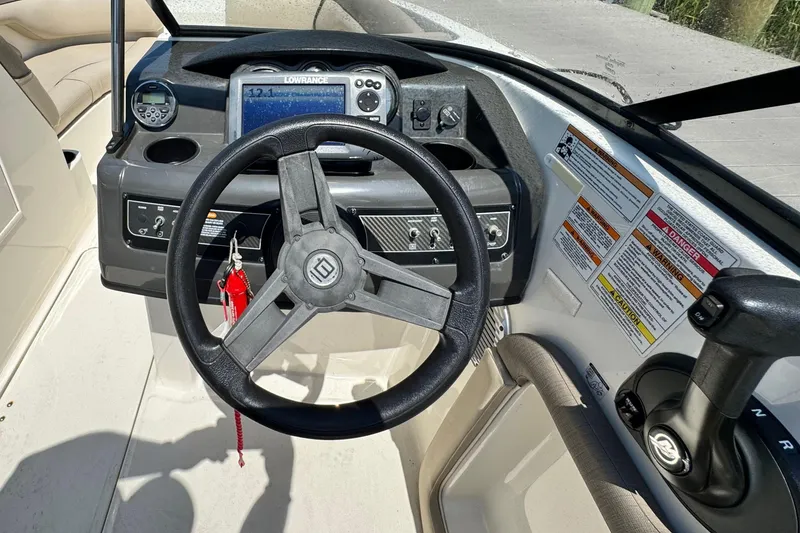 Slide: The Image of 2017 Bayliner 190 Deck Boat dashboard with steering wheel and control panel. - 14