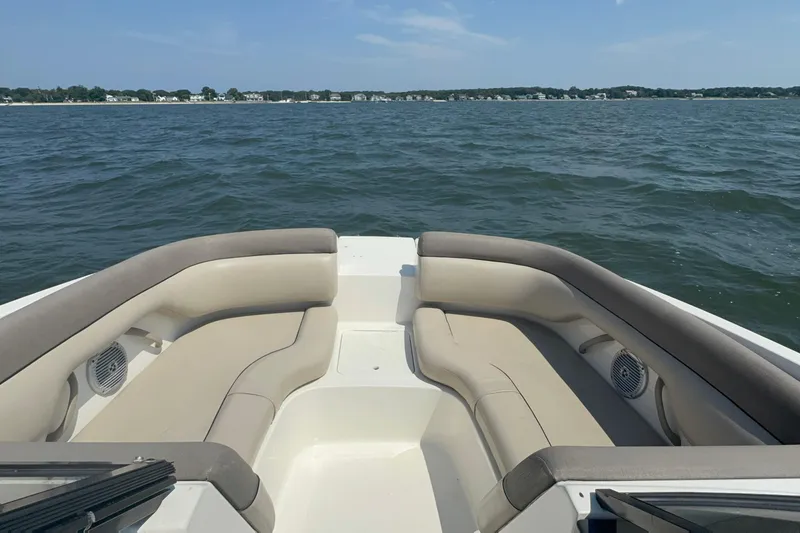 Slide: The Image of 2017 Bayliner 190 Deck Boat interior with cushioned seating on open water. - 15