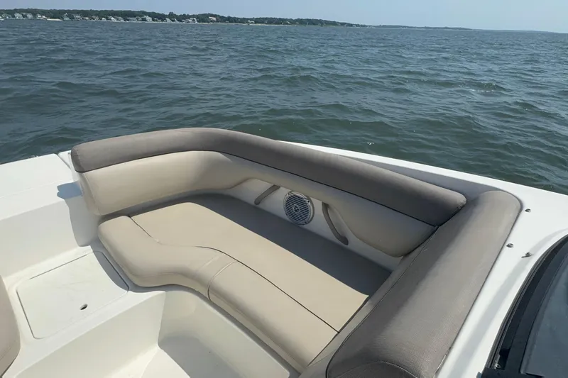 Slide: The Image of 2017 Bayliner 190 Deck Boat interior with cushioned seating on open water. - 16