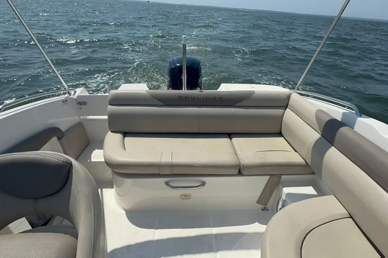 Slide: The Image of 2017 Bayliner 190 Deck Boat interior with seating, cruising on open water. - 8