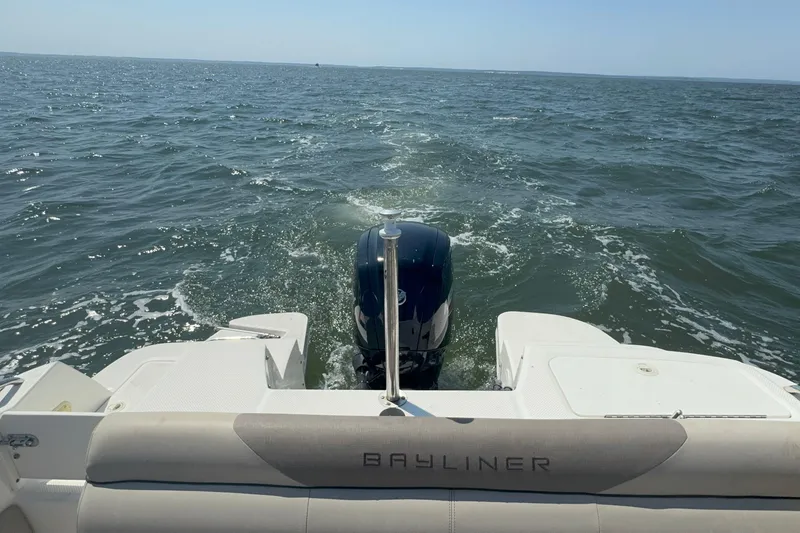 Slide: The Image of 2017 Bayliner 190 Deck Boat cruising on open water, rear view. - 9