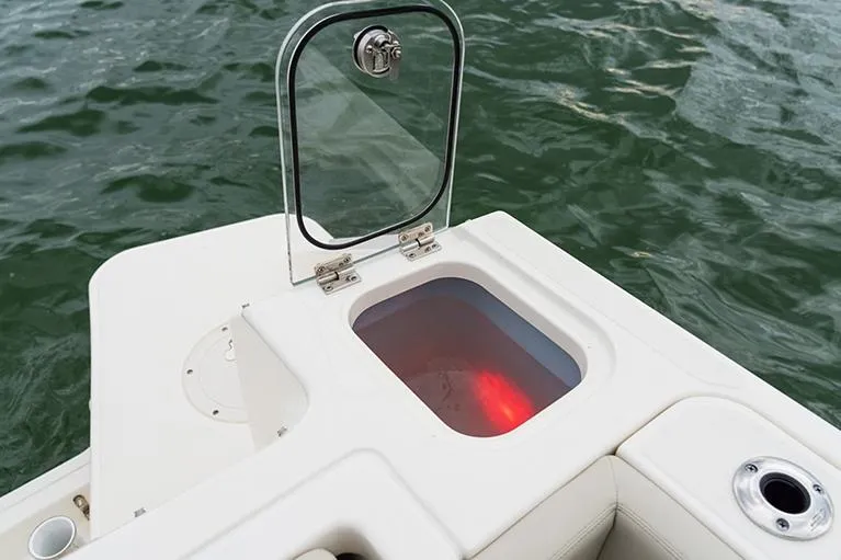 Slide: The Image of Manufacturer Provided Image: Boston Whaler 240 Vantage 2023 boat with open storage compartment on water. - 15