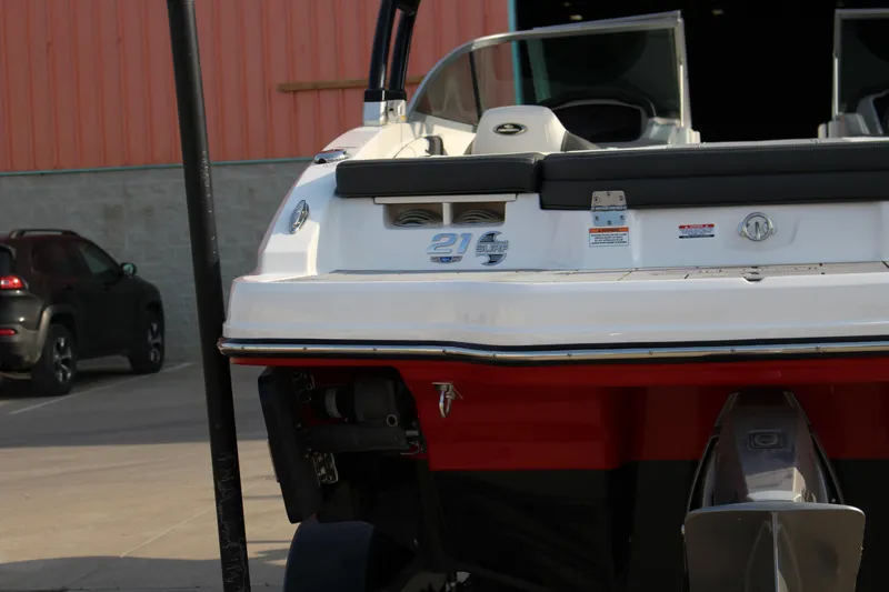 Slide: The Image of 2022 Chaparral 21 Surf boat rear view, parked near a building. - 5