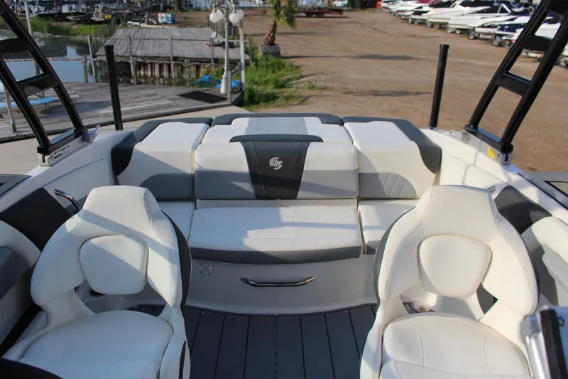 Slide: The Image of 2022 Chaparral 21 Surf boat interior with white seating and sleek design. - 8
